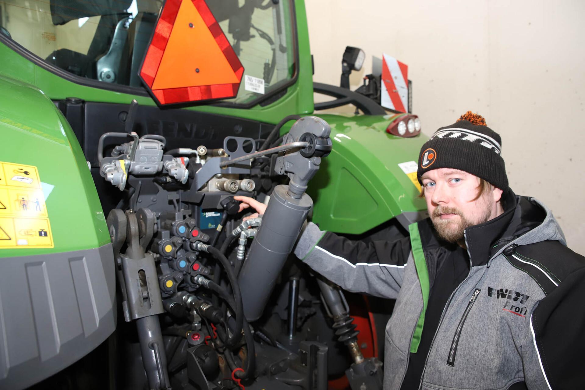 Viljelijä ja koneurakoitsija Teemu Vesa esittelee Fendt 724 -traktoriin asennettua automaattista Smart Top Link -työntövartta, joka pitää lannoitteenlevittimen aina vaakatasossa.