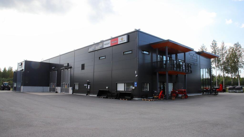 AGCO Suomen Joensuun piste ulkoa. Tummanharmaa iso hallirakennus missä vasemmalla puolella kuvassa on huollon ja pesun sisäänkäyntiovet ja oikealla pääsy myymälään.